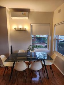 a dining room with a glass table and chairs at Peaceful Getaway! in Sydney