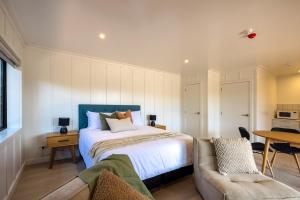 a bedroom with a bed and a couch at Onetangi Beach Stays Studio 1 - Coast & Country in Onetangi