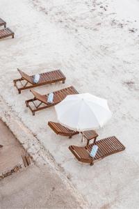 parasol i dwa stoły piknikowe na plaży w obiekcie AWA Holbox Hotel Boutique w mieście Isla Holbox