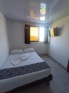 a bedroom with a large bed with a window at HOTEL NORCASIA RIOS Y AVENTURAS in Norcasia
