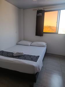 Schlafzimmer mit einem großen Bett und einem Fenster in der Unterkunft HOTEL NORCASIA RIOS Y AVENTURAS in Norcasia
