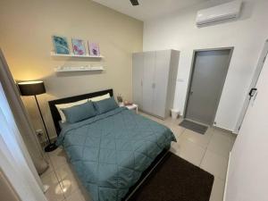 a bedroom with a bed with a blue comforter at Affordable Family Stay in Bangi in Kajang +23 photos