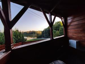 ventana en una habitación con vistas al campo en Bug Na Skarpie - Domek Wypoczynkowy z Jacuzzi i Kominkiem en Drohiczyn nad Bugiem