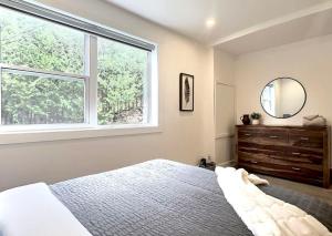 - une chambre avec un lit, une fenêtre et une commode dans l'établissement Le domaine du Sous-Bois, à Saint-Faustin–Lac-Carré