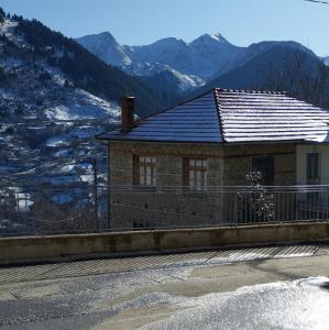 uma casa ao lado de uma estrada com montanhas em Primula em Metsovo