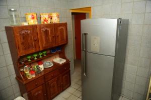 a kitchen with a refrigerator and a wooden cabinet at Excelente casa c lazer prox a praia Tamandare PE in Tamandaré