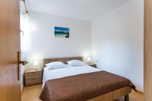 een slaapkamer met een bed en twee nachtkastjes met lampen bij Holiday Home Nina Plitvine in Vela Luka