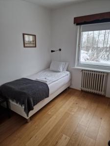 een kleine slaapkamer met een bed en een raam bij Spói Guesthouse in Hvolsvöllur