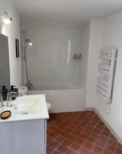uma casa de banho com um lavatório e uma banheira em Le "spacieux" en centre ville em Carpentras