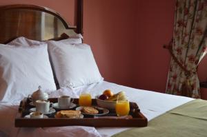 - un plateau de petit-déjeuner sur un lit avec du jus d'orange dans l'établissement Patios De Cafayate, à Cafayate