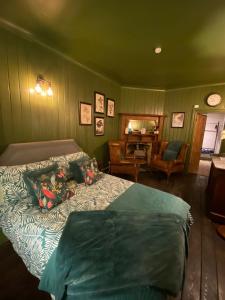a green bedroom with a bed and a chair at Petite Jessamine in St Margarets at Cliff
