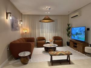 salon z kanapą i telewizorem w obiekcie شقة فاخرة بأسلوب فندقي و جلسة ريفية بدخول ذاتي w Rijadzie