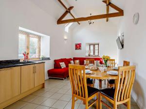 a kitchen and dining room with a table and a red couch at 3 bed in Taunton KIBOR in Trull