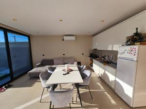 a kitchen and living room with a white table and chairs at Sunrise Villa in Rrushkull