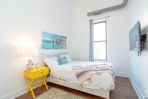 - une chambre avec un lit et une table de chevet jaune dans l'établissement McCormick Place 3BR-2BA with Optional Parking - sleeps 8, à Chicago