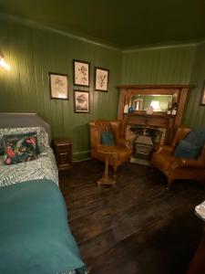Zimmer mit einem Bett, Stühlen und einem Kamin in der Unterkunft Petite Jessamine in St Margarets at Cliff