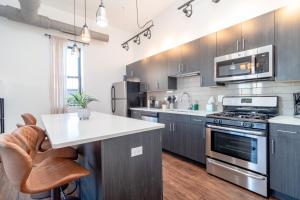 McCormick Place 3BR-2BA with Optional Parking - sleeps 8 في شيكاغو: مطبخ مع أجهزة ستانلس ستيل وقمة بيضاء