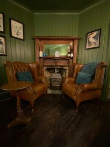 uma sala de estar com duas cadeiras e uma lareira em Petite Jessamine em St Margarets at Cliff