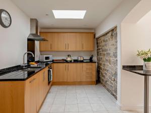 a kitchen with wooden cabinets and a brick wall at 2 Bed in Taunton KIBSH in Trull