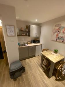 a small kitchen with a table and a table and chairs at Petite Jessamine in St Margarets at Cliff