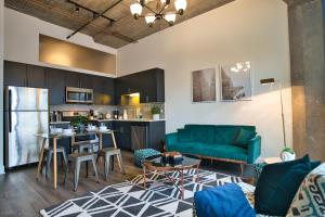 sala de estar con sofá azul y cocina en McCormick Place 2b-2b family unit with optional parking sleeps up to 6, en Chicago