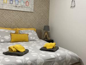 ヴィムルーにある"Appartement sur digue" proche de la plage avec wifiのベッド1台(上に黄色いタオル2枚付)