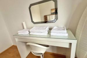 a bathroom with a table with a mirror and towels at Apartment 14 im Herzen von Linz in Linz