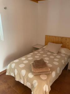 una camera da letto con un letto con una coperta marrone e un cuscino di Casitas Rurales AMADOR ad Arona