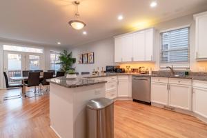 a kitchen with white cabinets and a table with chairs at Beautiful 5br home for 14 guests with free parking in Chicago