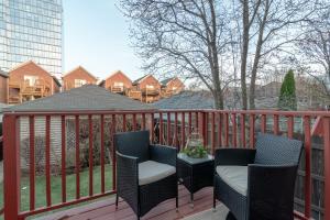 a balcony with two chairs and a table on a fence at Beautiful 5br home for 14 guests with free parking in Chicago