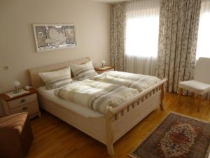 um quarto com uma cama grande e uma janela em Ferienwohnung Edmeier em Bernau am Chiemsee