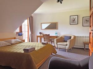 a bedroom with a bed and a chair and a desk at Brzozowy Dworek - Winnica Lipowiec in Lipowiec