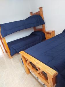 una camera con letto a castello e coperta blu di Cabaña en Cuadro Benegas a San Rafael