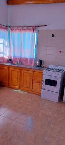 una cucina con piano cottura, lavello e forno a microonde di Cabaña en Cuadro Benegas a San Rafael