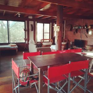 a dining room with a wooden table and red chairs at CASA QUINCHO in Jesús María