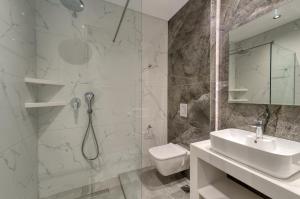 un bagno con doccia, lavandino e WC di Anesis Deluxe Apartment 1 a Gaïtánion Altre 12 foto