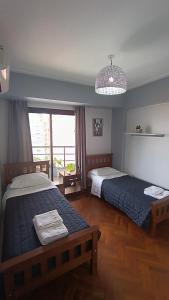 a bedroom with two beds and a large window at Nord Suite - Departamento Premium en Barrio Norte in San Miguel de Tucumán