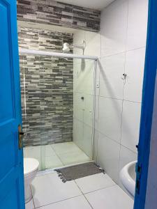 uma casa de banho com uma cabina de duche em vidro e um WC. em Beach Life Porto de Galinhas em Porto de Galinhas