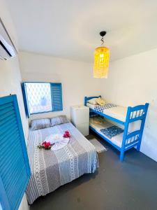 um quarto com duas camas e uma mesa com flores em Beach Life Porto de Galinhas em Porto de Galinhas