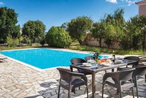 a patio with a table and chairs next to a swimming pool at Villa Olga in Katelios
