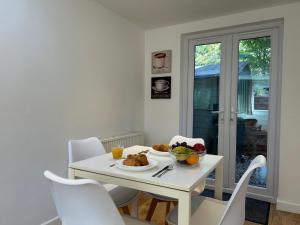 a white dining room with a white table and chairs at Stylish 1 Bedroom Flat with Parking in Oxford in Oxford