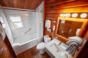 a bathroom with a toilet and a sink and a tub at Jasper House Bungalows in Jasper