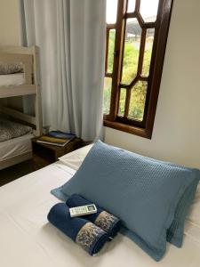 a bed with two pillows on it with a window at Casa Aconchego II in Pomerode