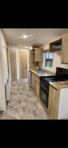 a kitchen with wooden cabinets and a stove top oven at Laguna- Rockley Park Poole in Poole