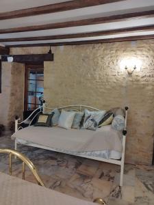 uma cama num quarto com uma parede de pedra em Stargazer Studio em Saint-Chamassy