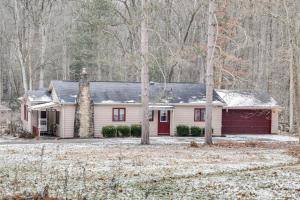 een wit huis met een rode garage in het bos bij Rector Home with Hot Tub about 6 Mi to Ligonier! in Rector