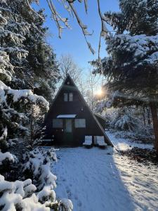 una cabaña en la nieve con el sol brillando en ella en Vakantiewoning Sunclass Durbuy Ardennen huisnummer 68 en Durbuy