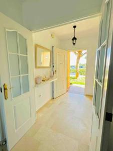 a hallway with an open door to a room with a kitchen at Adosado en Novo Atlantico Golf in Novo Sancti Petri