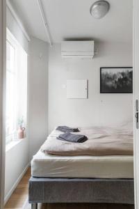 a bedroom with a bed in a white room at Hidden gem near the Old Town Bridge, 40m² apt. in Trondheim