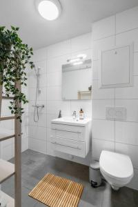 La salle de bains blanche est pourvue de toilettes et d'un lavabo. dans l'établissement Hidden gem near the Old Town Bridge, 40m² apt., à Trondheim